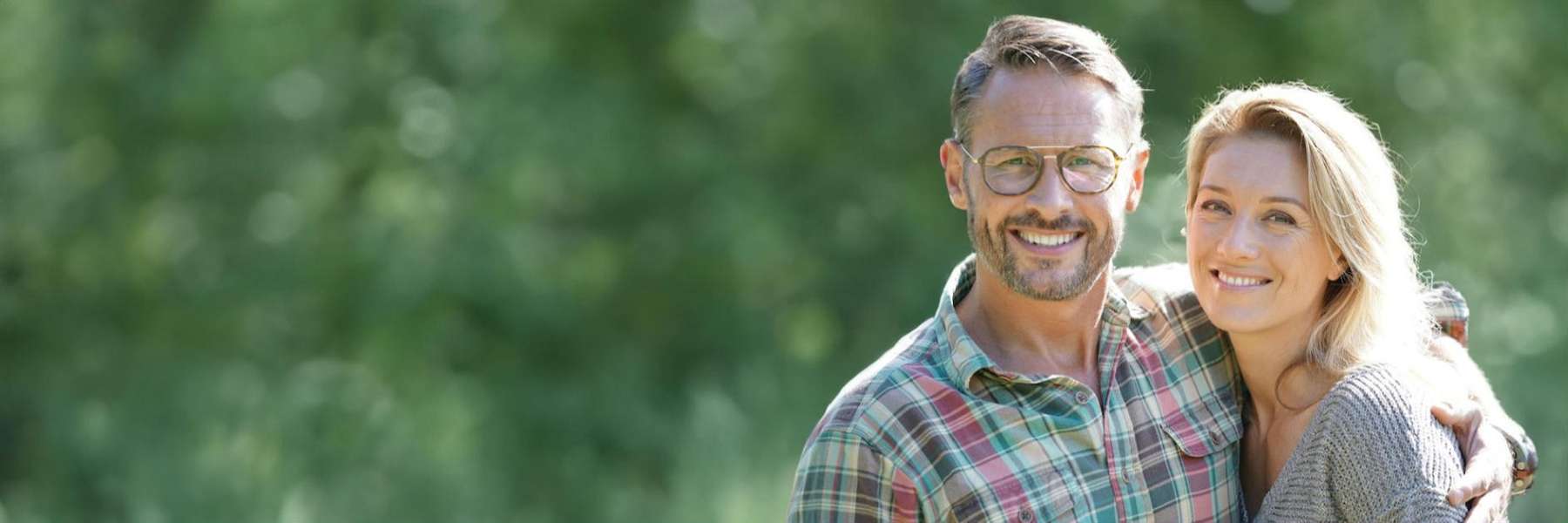 couple with implant dentures smiling in lithia, FL